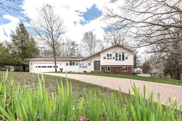 2277 W Huron River Dr, Ann Arbor, MI 48103 - tri-level home with decorative driveway and an attached garage