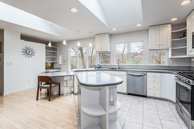 2277 W Huron River Dr, Ann Arbor, MI 48103 - kitchen with open shelves, appliances with stainless steel finishes, a sink, recessed lighting, and vaulted ceiling
