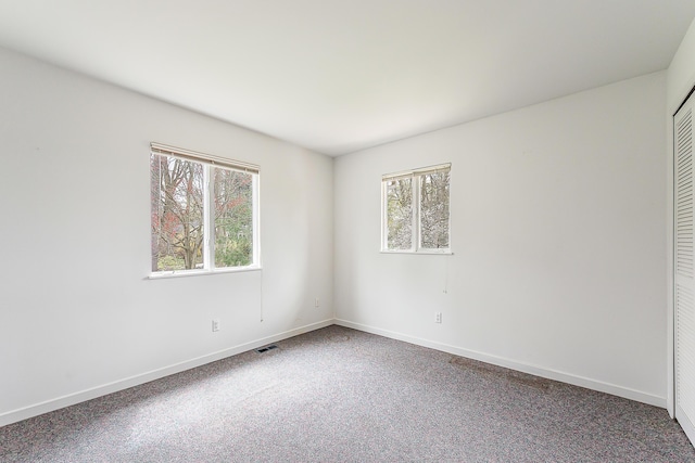 2277 W Huron River Dr, Ann Arbor, MI 48103 - unfurnished bedroom with baseboards, carpet, and a closet