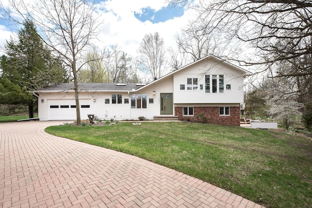 2277 W Huron River Dr, Ann Arbor, MI 48103 - tri-level home featuring a garage, decorative driveway, and a front yard