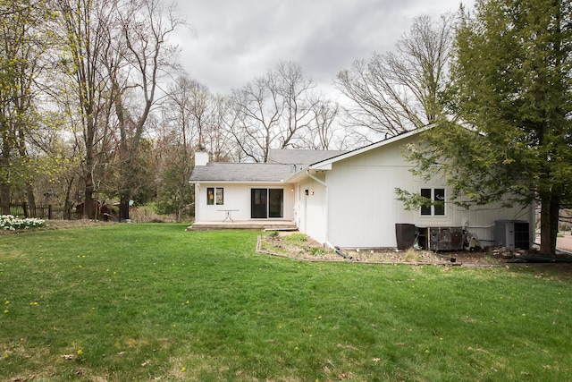 2277 W Huron River Dr, Ann Arbor, MI 48103 - back of property with a chimney, a lawn, and central AC unit