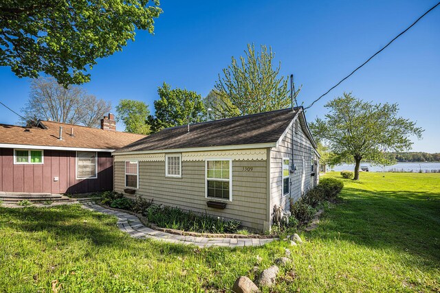 3309 Dumont Lake Dr, Allegan, MI 49010 - view of property exterior featuring a yard, a water view, a chimney, and a shingled roof