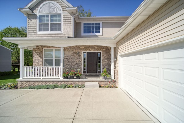 10478 River Edge Rd, Saline, MI 48176 - view of exterior entry with a porch, brick siding, a garage, and driveway