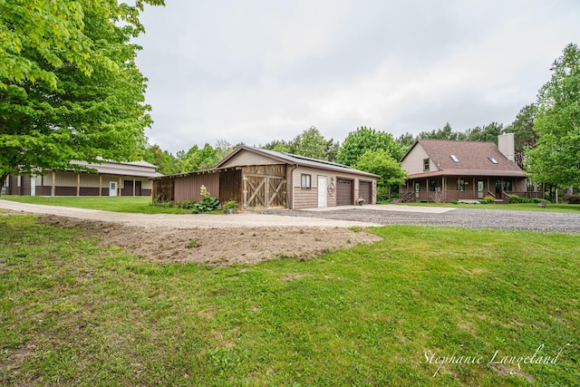 16913 Penny Ave NE, Sand Lake, MI 49343 - view of front facade with an outbuilding, a front lawn, and a detached garage