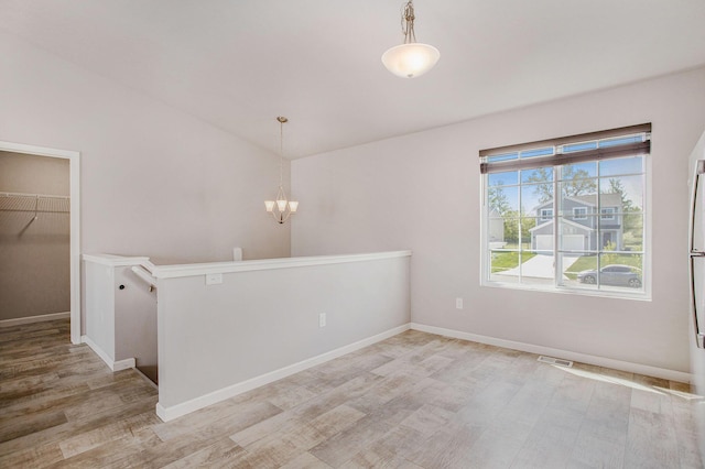 10315 Hatch Ln, Galesburg, MI 49053 - spare room featuring wood finished floors, a chandelier, baseboards, and lofted ceiling