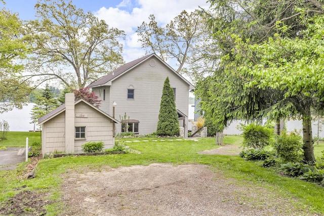 186 Goldsmith Dr, Clarklake, MI 49234 - view of property exterior featuring a lawn and a chimney
