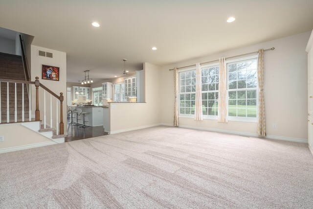 7294 Mackenzie Ln, Portage, MI 49024 - unfurnished living room featuring carpet flooring, recessed lighting, stairs, baseboards, and a chandelier