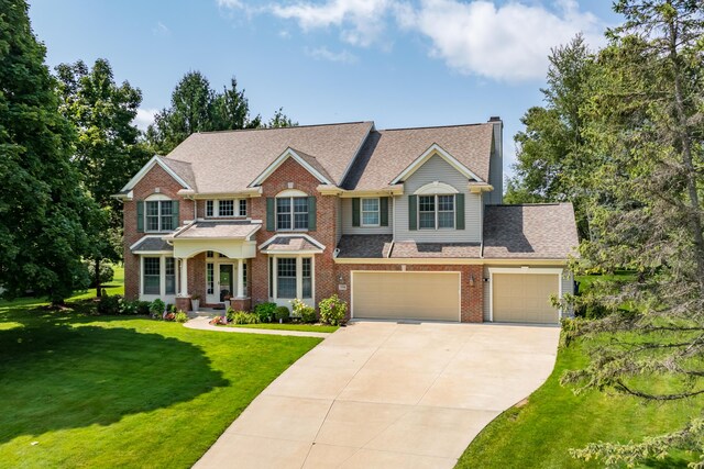 7294 Mackenzie Ln, Portage, MI 49024 - view of front of home featuring concrete driveway, brick siding, a front lawn, and a garage