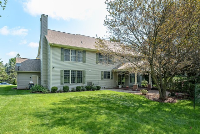 7294 Mackenzie Ln, Portage, MI 49024 - back of house with a chimney, a patio area, a yard, and a shingled roof