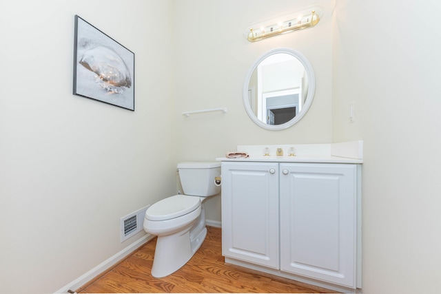 4980 Doral Dr, Ann Arbor, MI 48108 - bathroom featuring toilet, baseboards, wood finished floors, and vanity