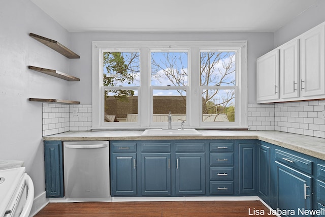 205 N Franklin St, Greenville, MI 48838 - kitchen with dishwasher, blue cabinetry, a sink, backsplash, and light countertops