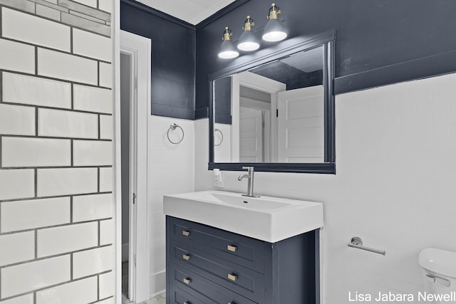 205 N Franklin St, Greenville, MI 48838 - bathroom with toilet, vanity, and tile walls