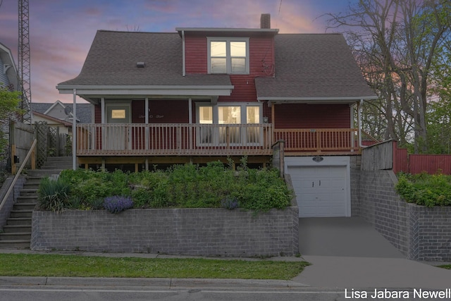 205 N Franklin St, Greenville, MI 48838 - view of front of property with stairs, driveway, a chimney, an attached garage, and roof with shingles