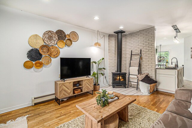 524 S Mears Ave, Whitehall, MI 49461 - living area with a wood stove, light wood-style flooring, a baseboard radiator, baseboards, and recessed lighting