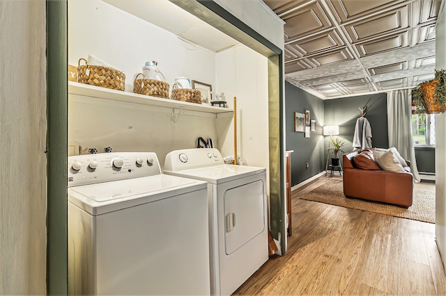 524 S Mears Ave, Whitehall, MI 49461 - laundry room featuring an ornate ceiling, separate washer and dryer, light wood-type flooring, baseboards, and a baseboard radiator