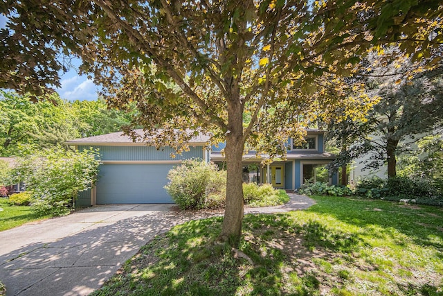 1410 N Folkstone Ct, Ann Arbor, MI 48105 - view of property hidden behind natural elements featuring concrete driveway, a garage, and a front lawn