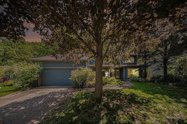 1410 N Folkstone Ct, Ann Arbor, MI 48105 - view of property hidden behind natural elements with concrete driveway, a garage, and a lawn