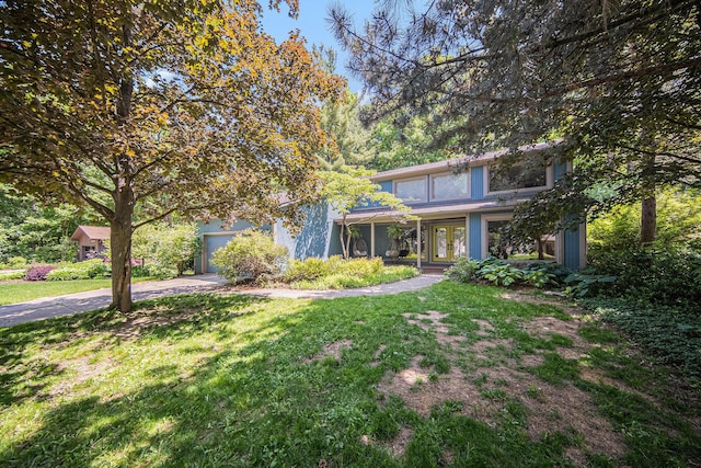 1410 N Folkstone Ct, Ann Arbor, MI 48105 - obstructed view of property with french doors, driveway, and a front lawn