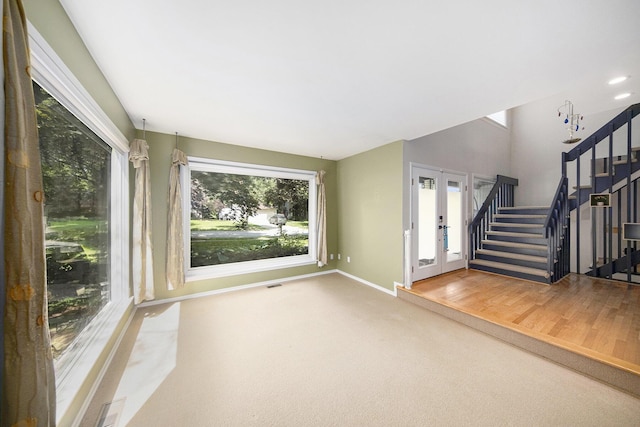 1410 N Folkstone Ct, Ann Arbor, MI 48105 - unfurnished living room with plenty of natural light, stairway, french doors, and carpet floors