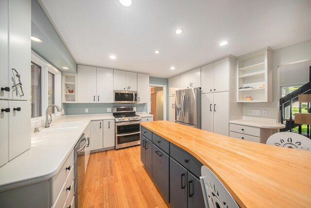 1410 N Folkstone Ct, Ann Arbor, MI 48105 - kitchen with appliances with stainless steel finishes, open shelves, butcher block countertops, a sink, and white cabinets