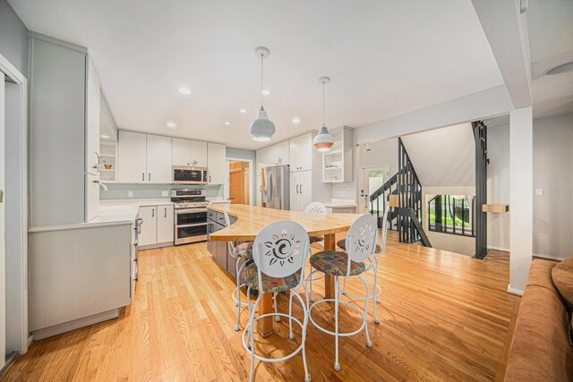 1410 N Folkstone Ct, Ann Arbor, MI 48105 - kitchen with stainless steel appliances, wood counters, light wood finished floors, white cabinetry, and recessed lighting