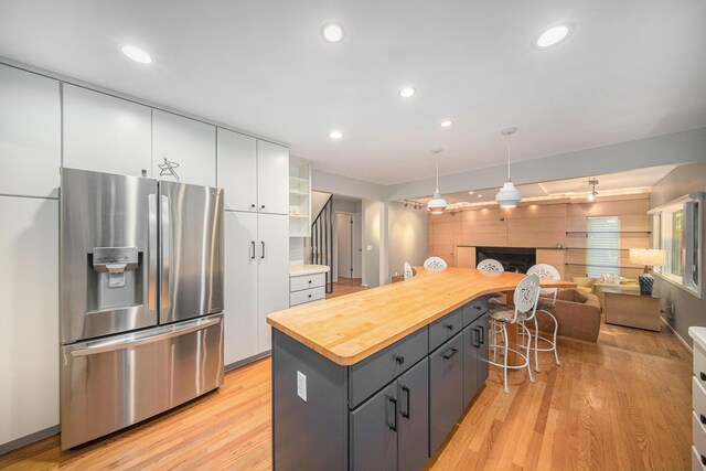 1410 N Folkstone Ct, Ann Arbor, MI 48105 - kitchen featuring stainless steel refrigerator with ice dispenser, white cabinetry, butcher block counters, light wood-type flooring, and a kitchen island