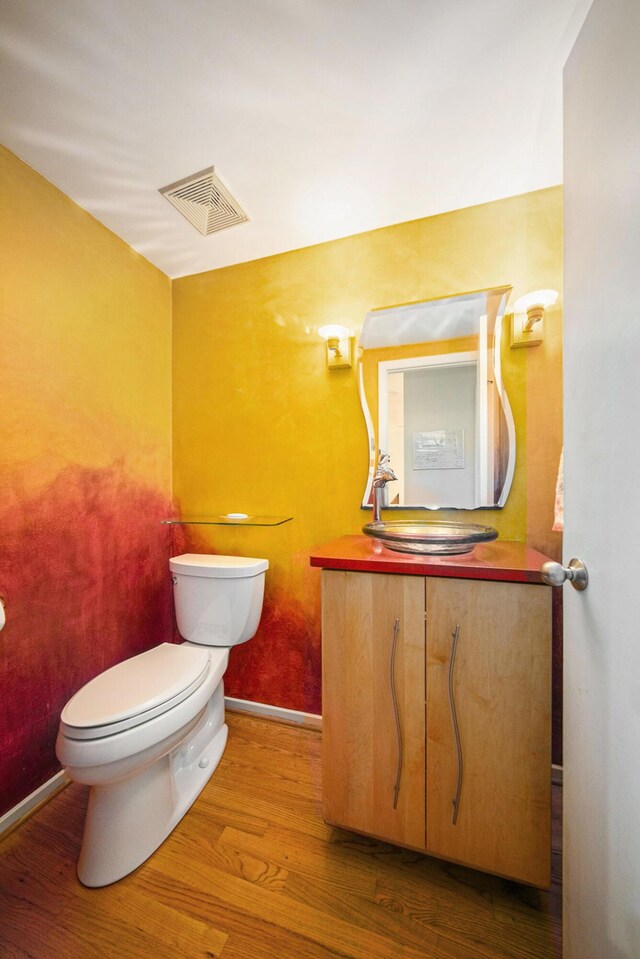 1410 N Folkstone Ct, Ann Arbor, MI 48105 - half bathroom with toilet, vanity, and wood finished floors