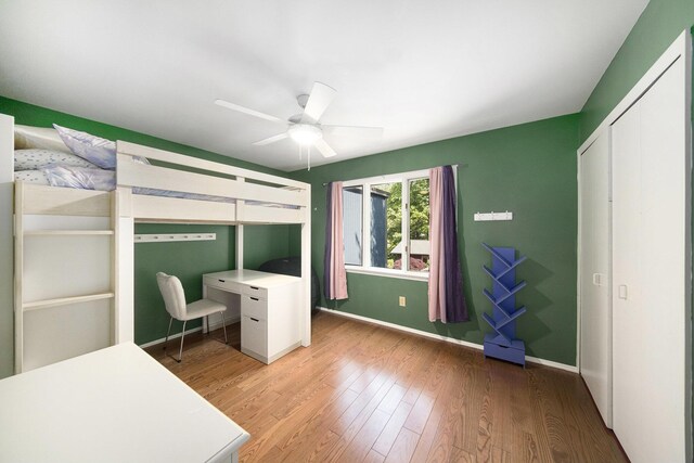 1410 N Folkstone Ct, Ann Arbor, MI 48105 - unfurnished bedroom featuring wood finished floors, baseboards, a ceiling fan, and a closet