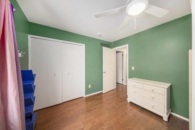 1410 N Folkstone Ct, Ann Arbor, MI 48105 - unfurnished bedroom featuring wood finished floors, a closet, a ceiling fan, and baseboards