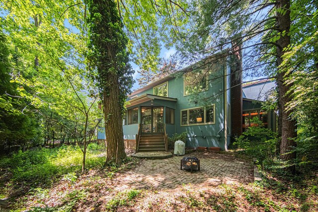 1410 N Folkstone Ct, Ann Arbor, MI 48105 - view of front of house with a sunroom and an outdoor fire pit