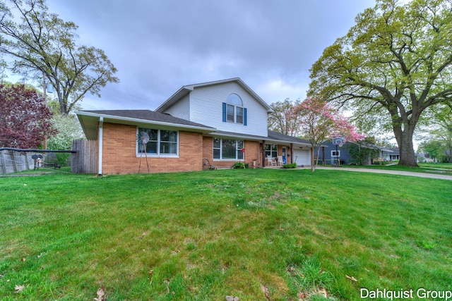 traditional-style home with an attached garage, brick siding, and driveway