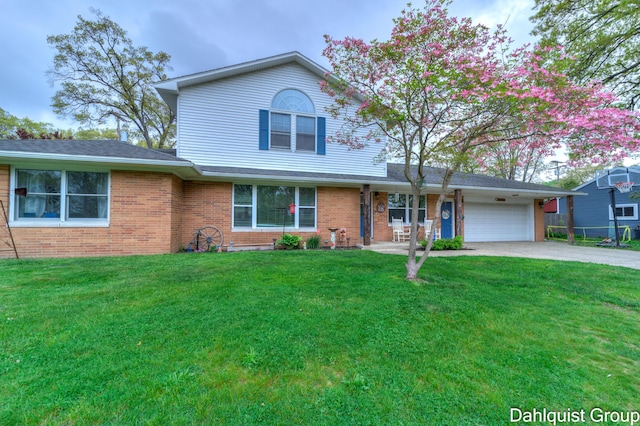 traditional-style house with brick siding, a front yard, and an attached garage