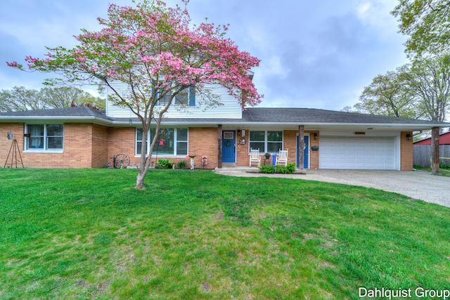 view of front facade featuring an attached garage, brick siding, a front yard, and driveway