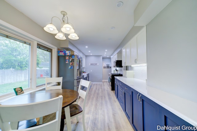 dining space with a chandelier, light wood finished floors, and recessed lighting