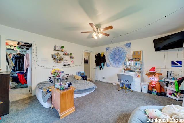 bedroom featuring carpet floors, a spacious closet, ceiling fan, and a closet