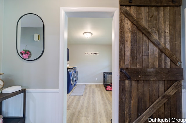 laundry room with independent washer and dryer, wood finished floors, and wainscoting