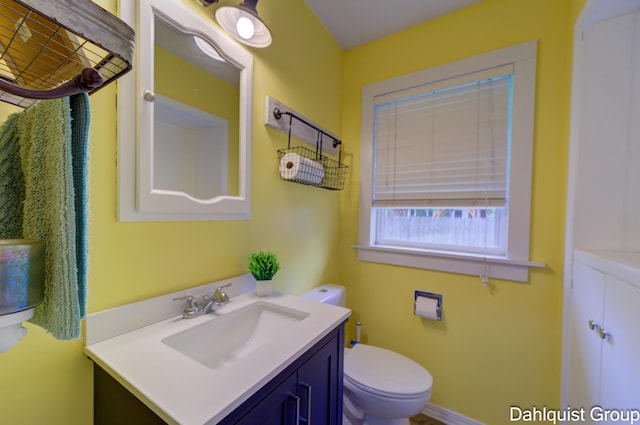 half bath featuring vanity and toilet