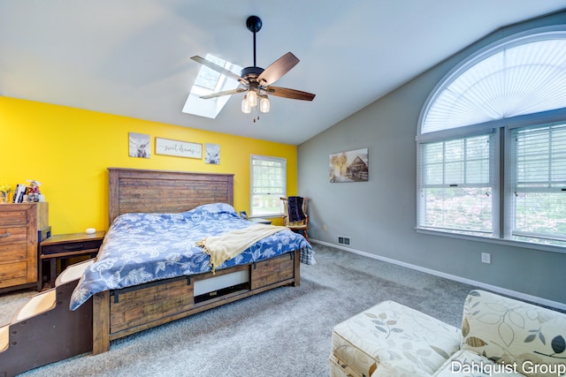 carpeted bedroom with lofted ceiling, a skylight, baseboards, and a ceiling fan