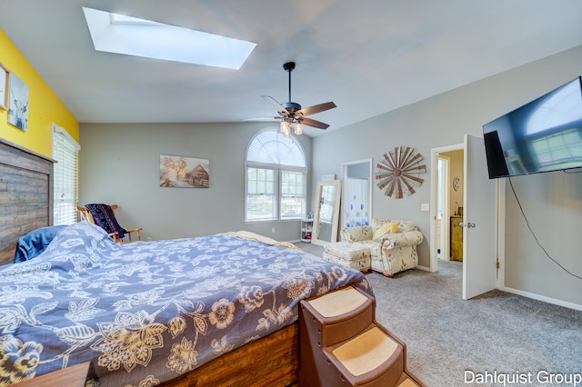 bedroom with a skylight, carpet, lofted ceiling, baseboards, and a ceiling fan