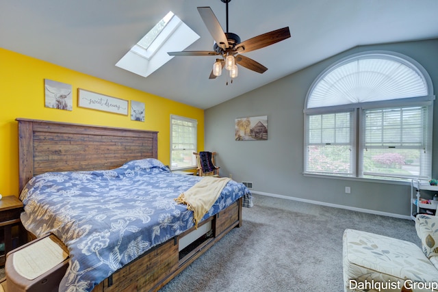 carpeted bedroom featuring lofted ceiling, a skylight, baseboards, and a ceiling fan