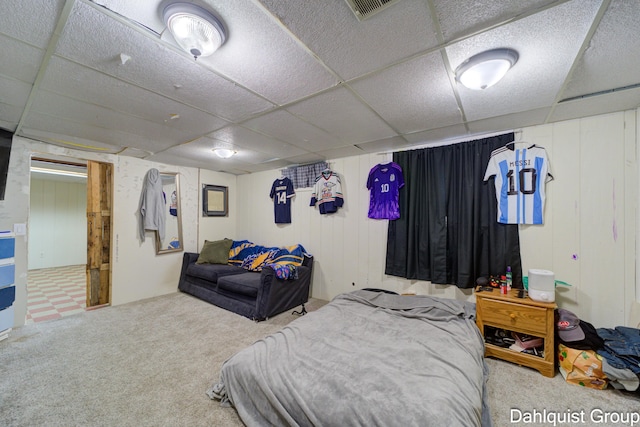 carpeted bedroom featuring a drop ceiling