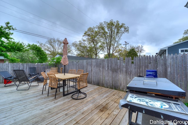 wooden deck featuring outdoor dining area and a fenced backyard