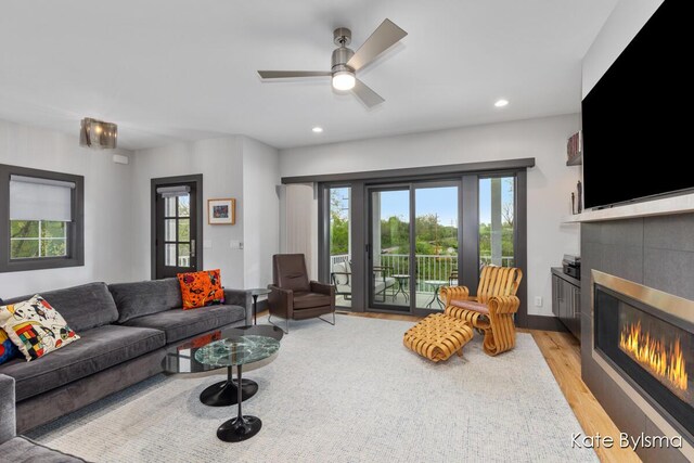 657 Greenslate Dr SE, Ada, MI 49301 - living room with a tile fireplace, light wood-type flooring, a ceiling fan, and recessed lighting