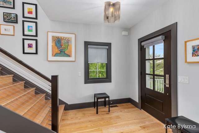 657 Greenslate Dr SE, Ada, MI 49301 - entryway with light wood-style flooring, stairway, and baseboards