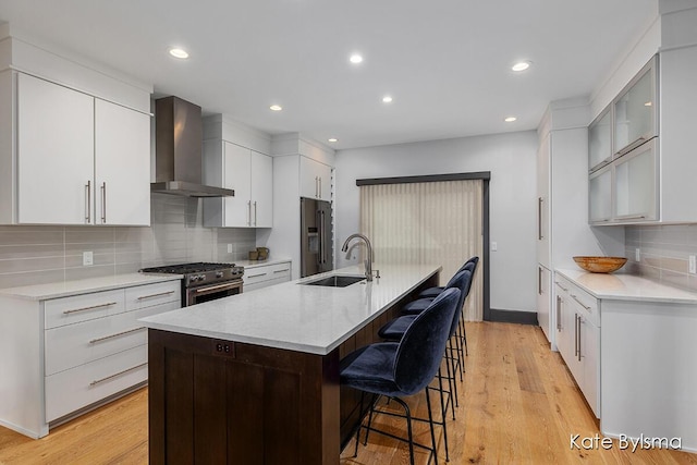 657 Greenslate Dr SE, Ada, MI 49301 - kitchen featuring wall chimney range hood, a sink, appliances with stainless steel finishes, a breakfast bar area, and tasteful backsplash