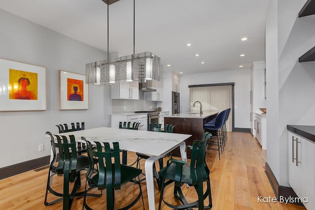 657 Greenslate Dr SE, Ada, MI 49301 - dining area with light wood-type flooring, recessed lighting, and baseboards