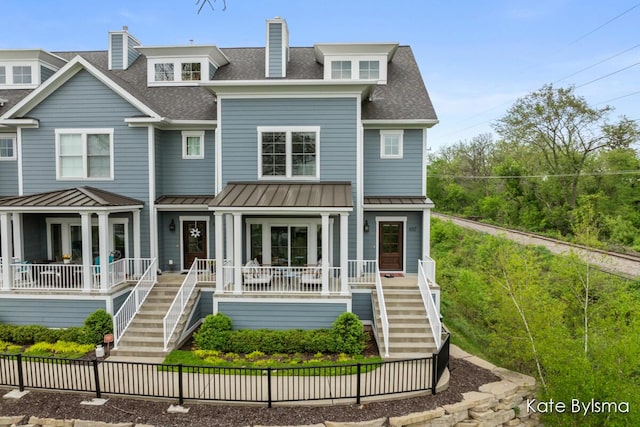 657 Greenslate Dr SE, Ada, MI 49301 - view of front facade featuring stairs, a shingled roof, and covered porch
