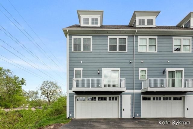 657 Greenslate Dr SE, Ada, MI 49301 - rear view of property with asphalt driveway, an attached garage, and a balcony