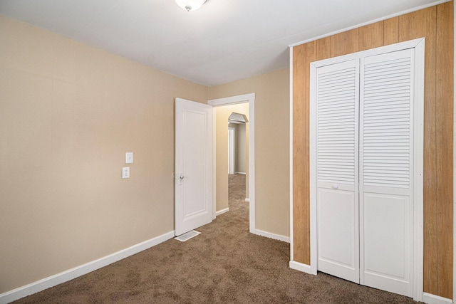 2335 Holmes Rd, Ypsilanti, MI 48198 - unfurnished bedroom with a closet, dark carpet, and baseboards