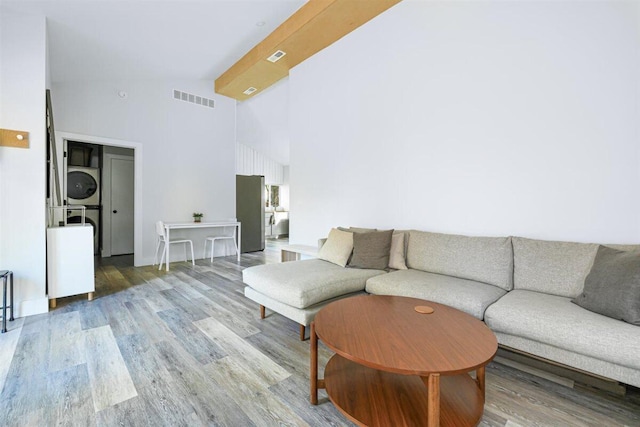 6800 Harbert Rd, Harbert, MI 49115 - living area with stacked washer / drying machine, wood finished floors, and high vaulted ceiling